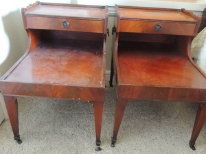 lot 13 image: Antique wheeled side tables with drawer, leather top with gold stenciling. 23H x18W x28L.1 wheel needs reattached Set of 2