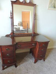 lot 19 image: Cherry knee hole vanitydesk with mirror and glass fitted top, 7 drawers. Vanity 29x48x19 mirror 41x40 also includes vintage tufted vanity sweetheart chair 30x14