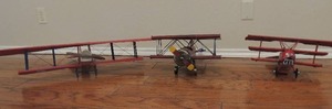 lot 58 image: RED WOOD PLANE -   #1  20 x 28W wings,  RED METAL  #10 plane 15x14x8  Biplane,    German plane by Metal Tri wing 14x15x8
