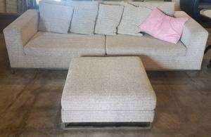 lot 36 image: Cushioned sofa with matching ottoman in stylecolorcondition shown.