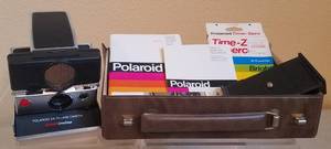 lot 17 image: VINTAGE POLAROID SX-70 LAND CAMERA SONAR ONESTEP WITH ORIGINAL MANUAL, PAPERWORK, AND UNOPENED FILM IN STORAGE BOX AS SHOWN. MUST SEE