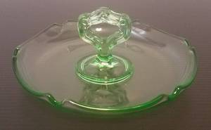 lot 69 image: VINTAGE GLASS DRESSER CATCH ALL RING DISH WITH CENTER HANDLE IN STYLECOLORCONDITION SHOWN. MEASURES APPROX. 6 x 2.5.