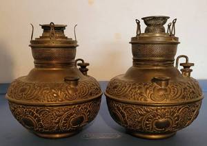 lot 91 image: RARE FIND ANTIQUE PAIR OF MILLER FULLY EMBOSSED BRASS OILKEROSENE LAMPS WITH GLASS CHIMNEYS (NOT PICTURED) IN SOLID OVERALL CONDITION. MARKED THE MILLER LAMP MADE IN USA. EACH APPROX. 6.25 x 7.5 WO CHIMNEYS. CIRCA 1890S. (YOUR BID X 2)