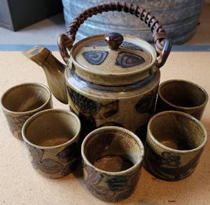 lot 187 image: VINTAGE 1960S STONEWARE OMC JAPAN POTTERY TEA SET IN STYLECOLORCONDITION SHOWN. TEAPOT HAS A RATTAN HANDLE.