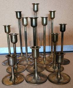 lot 195 image: LOT OF 13 BRASS CANDLESTICK HOLDERS IN VARIOUS SIZES RANGING FROM 3.25 TO 9.25 HIGH. THESE COME WITH LEATHER-LIKE STORAGE SLEEVES AS SHOWN. (YOUR BID X 13)