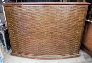 lot 216 image: VINTAGE CURVED WOODEN DRY BAR WITH WOVEN STYLE FRONT TWO LOCKABLE DOORS WITH KEYS, DRAWER, AND STORAGE SECTIONS IN STYLECOLORCONDITION SHOWN. MEASURES APPROX. 59 W x 20 D x 43 HIGH. CHECK IT OUT