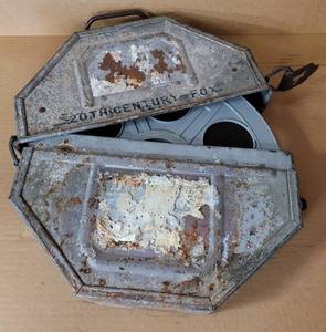 lot 51 image: VINTAGE METAL MOVIE REEL BOX WITH FILM STRIP AS SHOWN.