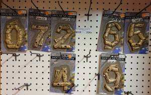 lot 224 image: LOT OF CAST IRON HOUSE NUMBERS IN PACKAGES AS SHOWN.