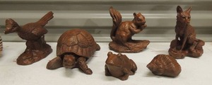 lot 40 image: Various Red mill hand carved wood art- turtle, road runner, seashell, squirrel, wolf & frog all in wicker basket