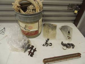 lot 171 image: Fence post tops, clamps, metal pieces 5 gal. bucket with large rope in it