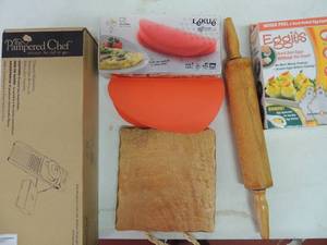 lot 181 image: Pampered chef NIB grater, small wooden cutting board, Lihue, omelet maker roller pen eggies make boiled egg no shells