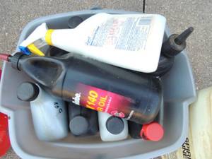 lot 256 image: Different types of open motor oil, paint thinner, and 2 gal gas can