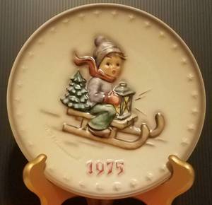 lot 29 image: 1975 M.J. HUMMEL PORCELAIN AND HAND PAINTED 5TH ANNUAL PLATE IN ITS ORIGINAL BOX AND IN EXCELLENT CONDITION AS SHOWN. MEASURES APPROX. 7.5 IN DIAMETER.