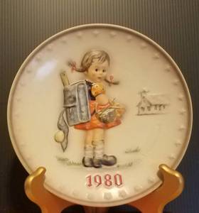 lot 34 image: 1980 M.J. HUMMEL PORCELAIN AND HAND PAINTED 10TH ANNUAL PLATE IN ITS ORIGINAL BOX AND IN EXCELLENT CONDITION AS SHOWN. MEASURES APPROX. 7.5 IN DIAMETER.