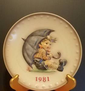 lot 35 image: 1981 M.J. HUMMEL PORCELAIN AND HAND PAINTED 11TH ANNUAL PLATE IN ITS ORIGINAL BOX AND IN EXCELLENT CONDITION AS SHOWN. MEASURES APPROX. 7.5 IN DIAMETER.
