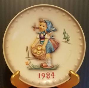 lot 38 image: 1984 M.J. HUMMEL PORCELAIN AND HAND PAINTED 14TH ANNUAL PLATE IN ITS ORIGINAL BOX AND IN EXCELLENT CONDITION AS SHOWN. MEASURES APPROX. 7.5 IN DIAMETER.