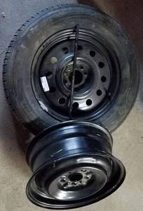 lot 296 image: 21565R16 SPARE TIRE IN LIKE-NEW CONDITION PLUS EXTRA WHEEL AND TIRE LUG NUT TOOL AS SHOWN.