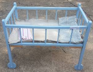 lot 534 image: ANTIQUE WOOD CHILDS PLAY CRIB IN STYLECOLORCONDITION SHOWN. CRIB HAS ORIGINAL WOOD WHEELS AND LINENS.