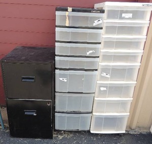lot 203 image: 2 rolling carts. White one has 8 pull out drawers and black one has 7. Black metal 2 drawer filing cabinet