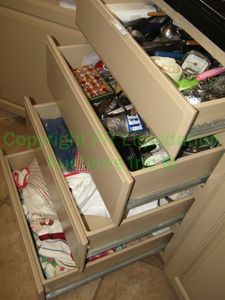 lot 303 image: Contents of 4 drawers including dish towels, utensils plus