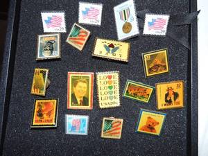 lot 337 image: U.S. postal service pins (17) love x 2, mummy, honoring those that serve, Cinco de Mayp, regan, dogtag, flagx2, teddy bear, vietnam memorial, texas, I want you and 4 in plastic