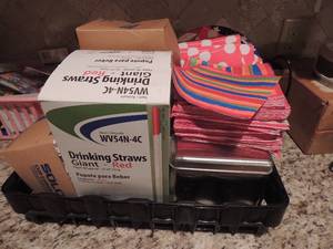 lot 185 image: Paper goods plates napkins straws and tin full of colorful plastic spoons