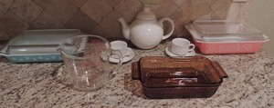 lot 108 image: Pink Swirl  Pyrex Casserole dish with lid, Blue SNOWFLAKE  covered Pyrex casserole dish.  white tea pot with 2 cups and plates and Pyrex measuring copy