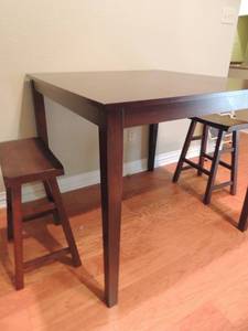 lot 7 image: Dining Table - Bar Height  approx 42 x 42  &  Pair of dark brown bar stools 24x17x 9