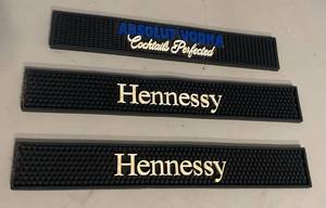 lot 21 image: Rubber Bar Service mats  Hennessys 23.5 x 3.25 Absolute Vodka 20.5 x 3.5