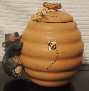 lot 92 image: 8x8 bee hive cookie jar with bear climbing up side. Honary written on bottom