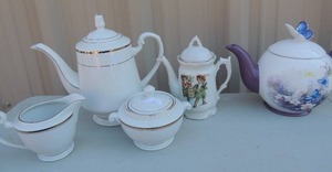 lot 148 image: White and gold teapot, sugar and creamer set, boy and girl teapot, and Lena  lici blossoms and butterflies teapot