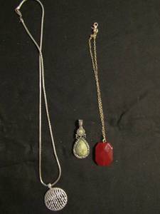 lot 342 image: 3 necklaces- Avon red cut stone, silver chain with bejeweled disk and green magnetic clip neck pendant