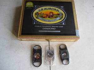 lot 89 image: La Aurora-1903 Edition Wooden Cigar Box, And 3-New Cigar Cutters.