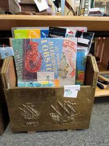 lot 703 image: EMBOSSED BRASS MAGAZINE HOLDER WITH PLACEMATS, LINEN TOWEL AND MORE AS SHOWN.