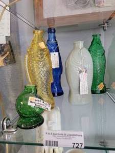 lot 727 image: GLASS FISH BOTTLES INCLUDING VINTAGE MINI WHEATIN, COBALT BLUE, AND MORE AS SHOWN.