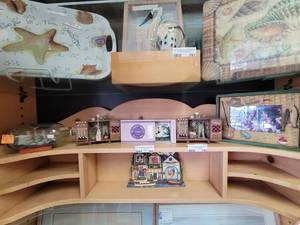 lot 792 image: CONTENTS OF DISPLAY SHELF INCLUDING MATCH BOX CLOCK, PHOTO FRAMES, DECOR, SHIP IN A BOTTLE AS SHOWN. SHELF NOT INCLUDED