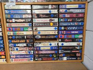 lot 1000 image: LOT OF ASSORTED VHS MOVIES IN WOODEN DISPLAY AS SHOWN.