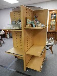 lot 910 image: 4-SIDED STORE DISPLAY UNIT WITH SHELVES AND ROLLERS IN STYLECOLOR SHOWN. CONTENTS SHOWN NOT INCLUDED (DELAYED PICK UP BETWEEN 200 PM AND 400 PM)