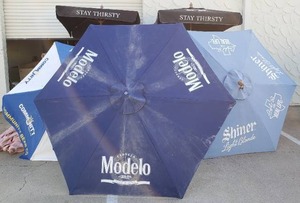 lot 153 image: Outdoor Patio Umbrellas, with Beer Logos Modelo ,Dos Equis XX, Community (missing Center Guide) and Shiner (5 Total)