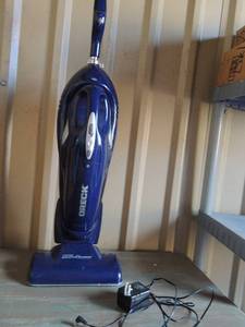 lot 63 image: Blue cordless Oreck vacume mini with charger (unknown working condition)