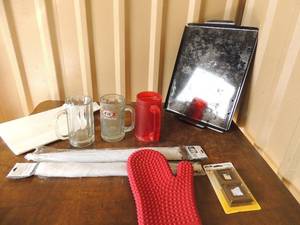 lot 93 image: Rubber oven mitt, 17x17 mesh food x2 NIP, 3 mugs, 2 metal cookie sheets
