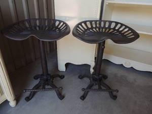 lot 4 image: 2 cast iron backless bar stools with foot rest. Can swivel or lock in place 25x18x14.