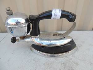 lot 181 image: Metal iron with handle  has gassteam chamber marked coleman instant life model #609 made in USA 8x4x6