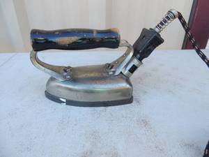 lot 215 image: Metal iron with handle and electric cord marked Westinghouse electric mfg. co.100-107 v 500 watt 6 lbs.  Style 150950 6x5x4
