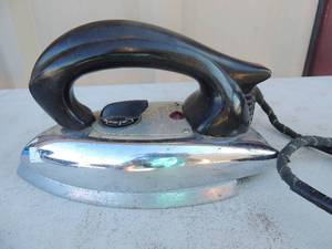 lot 220 image: Metal iron with handle and outlet plug. Marked Pominion electrical mfg. inc.110-120 volt 1000 watts USA 7x4x5