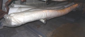lot 322 image: Long fabric rolls on bottom rack only.  White fabrics w various patterns.