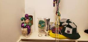 lot 78 image: Mardis Gras Baby Doll Jester and Assorted Bead Necklaces, Checkered Tall Fleece Hat, Pat OBriens 75th Anniversary Chalice