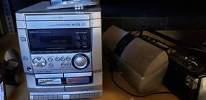 lot 23 image: Aiwa CX-NAJ10 3 CD Player, Global Phone Adapter Kit, Pioneer Digital Wireless Rear Speaker System Model XW-HTD630A, Panasonic RadioCassette Player Model RX-FM16
