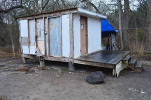 lot 824 image: Small out building on piers with deck and steps.