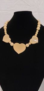 lot 741 image: Italian made cream  Butterscotch Bakelite necklace with heart motif. Marked with sticker Made in Italy. 19L